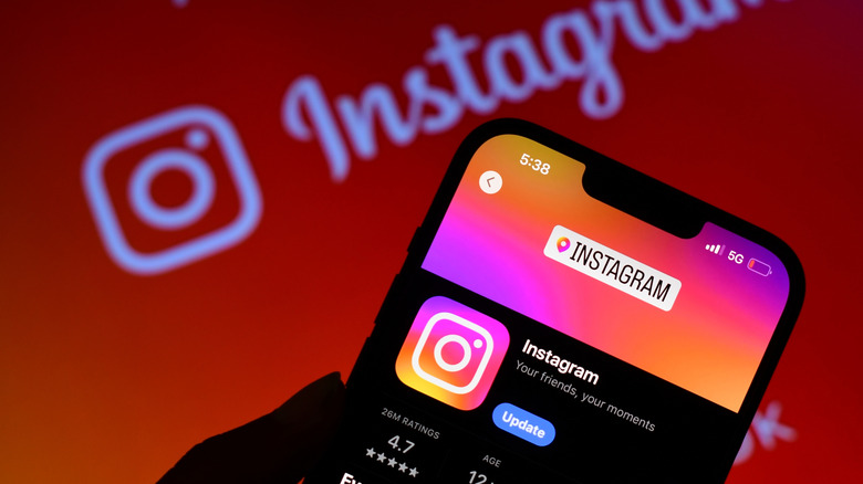 Instagram app displayed on a phone and the logo on the background.