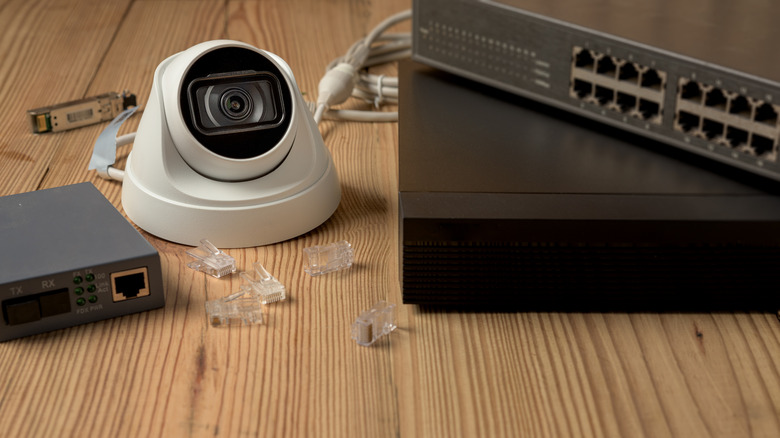 PoE network switch connected to an IP security camera with an Ethernet cable.