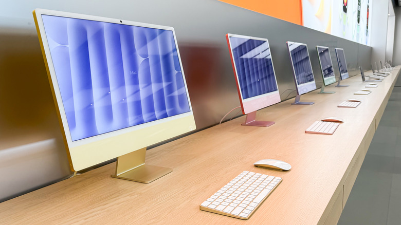 Multiple iMac units on a table at an Apple Store.