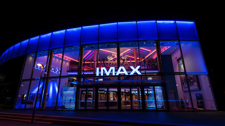 A blue-lit glass facade shows the iconic IMAX logo above the entrance to the Traumpalast Leonberg cinema complex.