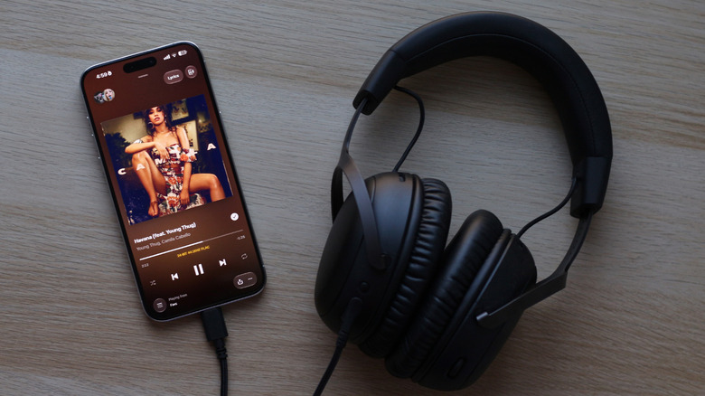 Wired headphones connected to a phone.