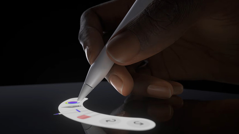 A hand holding an Apple Pencil Pro chooses between several tools on a white palette against a black screen and background.