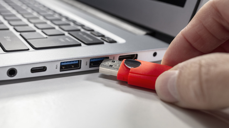 A USB thrust being plugged into a laptop