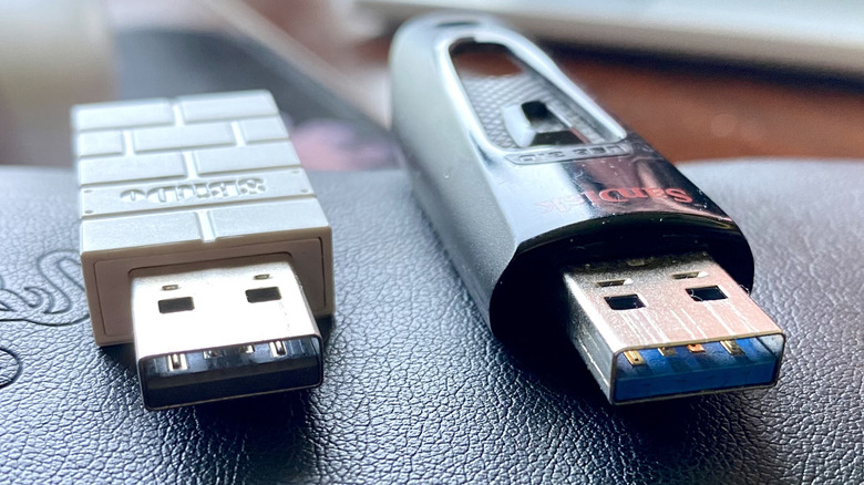 A USB 2.0 wireless gamepad dongle adjacent to a USB 3.0 USB flash drive