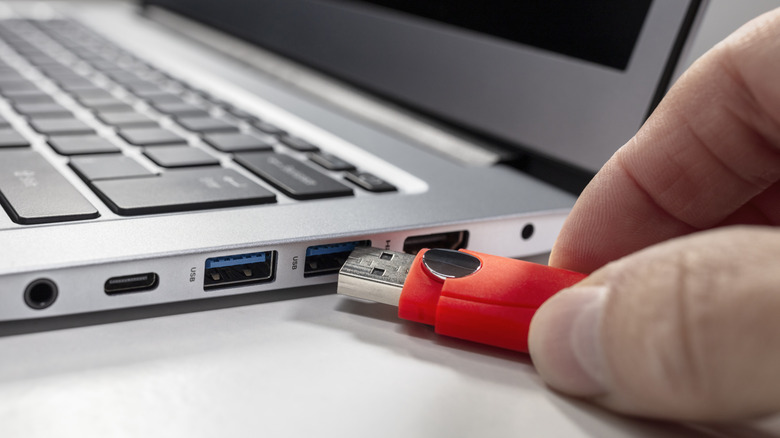 A USB drive being plugged into a laptop