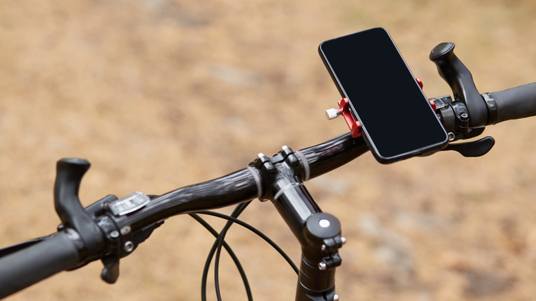 A smartphone mounted on the handlebar of a bike.