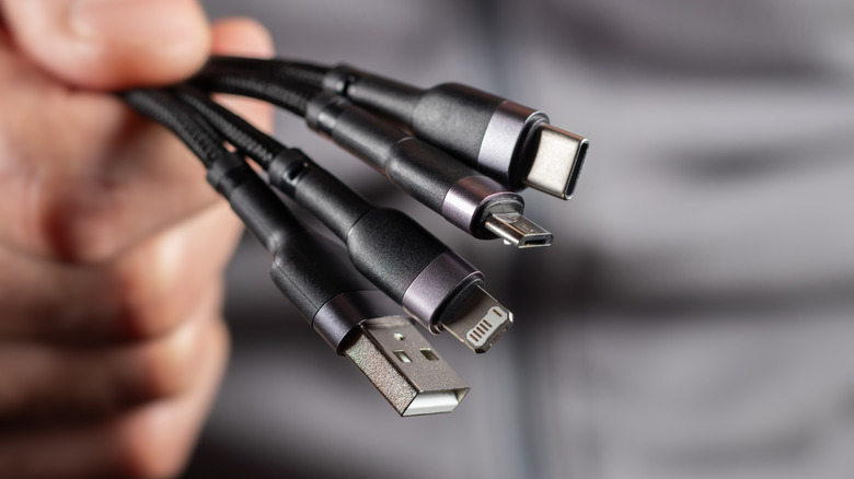 Many types of USB cables held in a hand