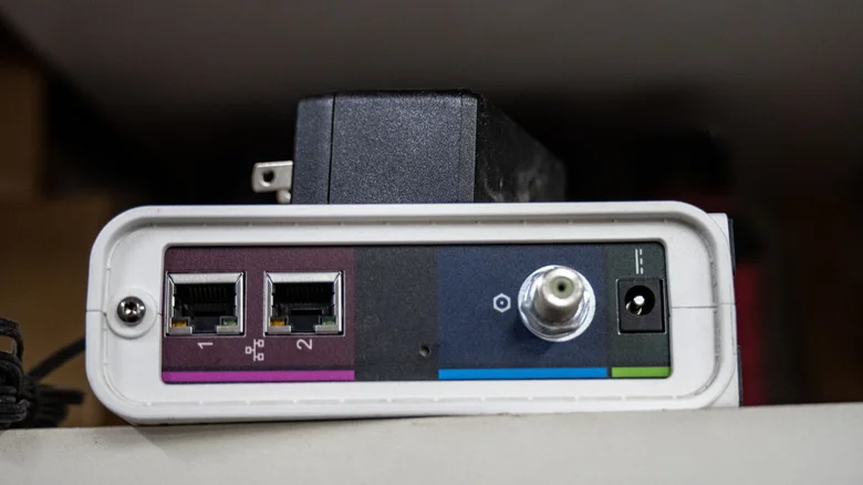The back of a cable internet modem, showing the coaxial cable and Ethernet ports.