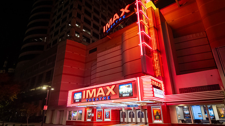 The entrance to an illuminated IMAX movie theater at night.