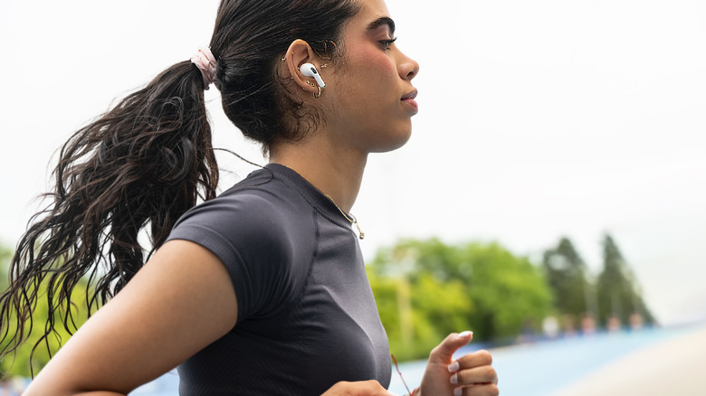 A woman running and listening to music on her AirPods.