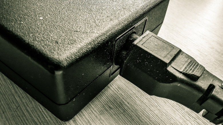A close-up of a dusty laptop charger.