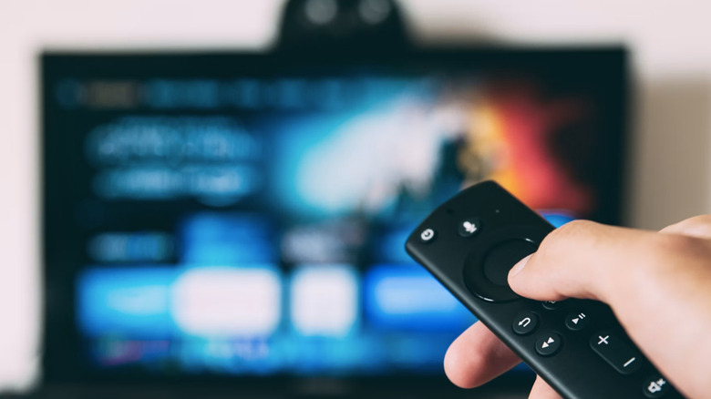 A remote control in the foreground, and in the background is a blurry TV.