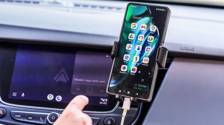 Phone connected to the car's system by wired, with Android Auto in the background