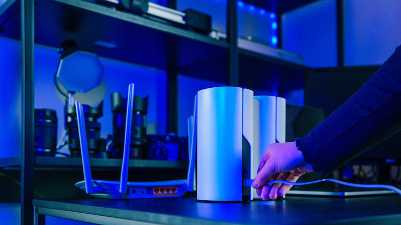A pair of mesh Wi-Fi routers next to a standalone unit.