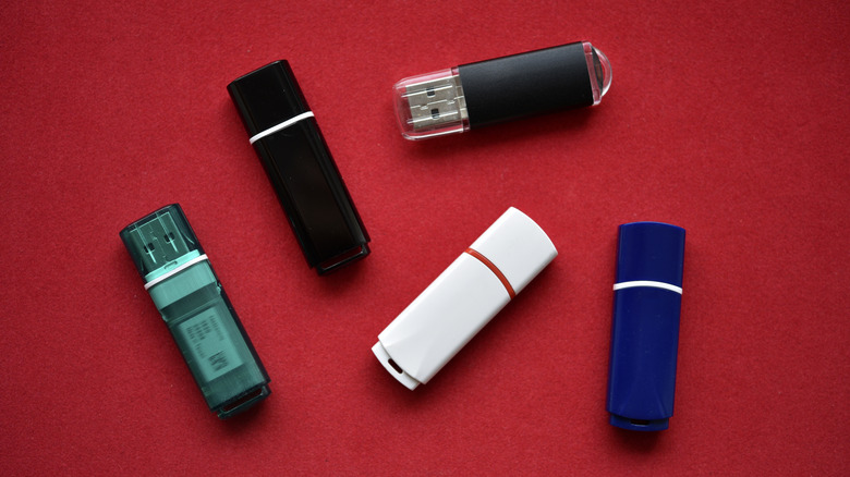 A bunch of USB flash drives on a red background.