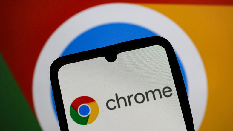 Google Chrome logo displayed on a smartphone screen with a Google web logo in the background.