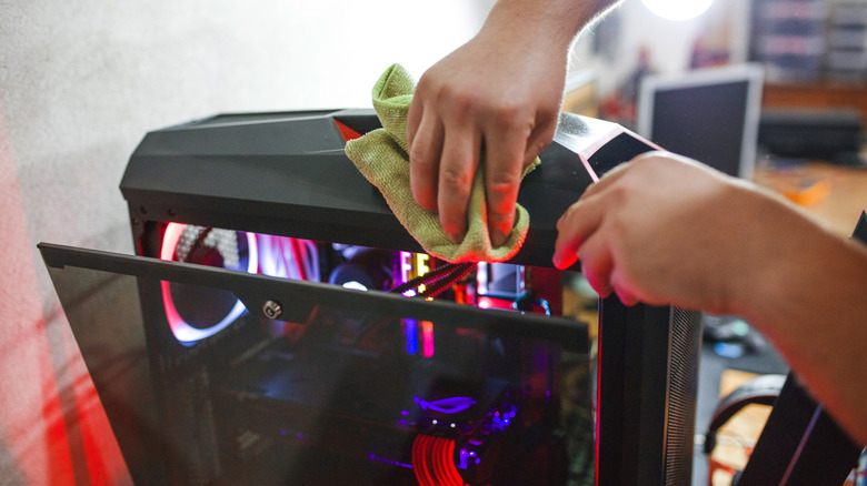 Person cleaning a PC tower.