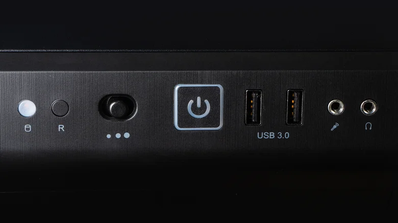 A desktop PC's power button, alongside various ports.