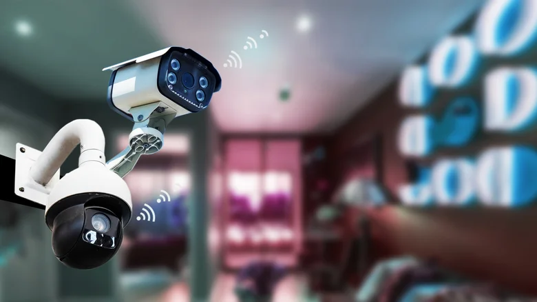 Image of a white security camera against a blurred background.