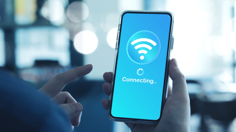 A hand holding a phone that's having connectivity issues.