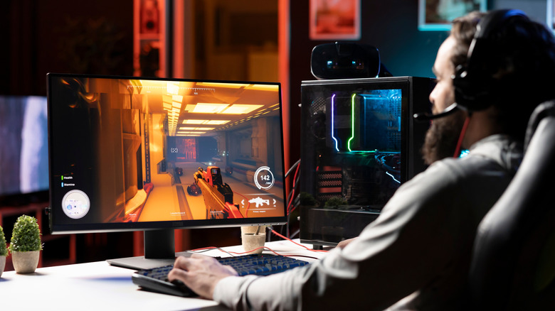 Pro gamer wearing headphones, competing in intense online multiplayer videogame.