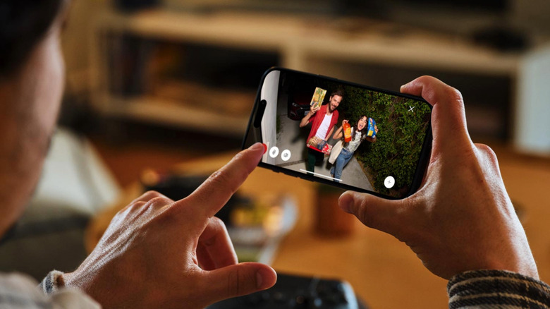 A person using the Ring app to see guests coming over with food.