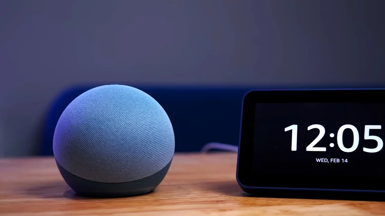 Echo Dot speaker sitting next to a digital clock display.