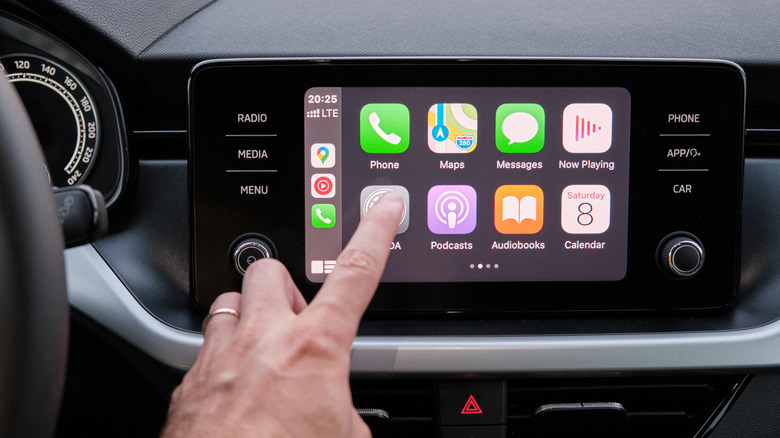 Person interacting with Apple CarPlay.