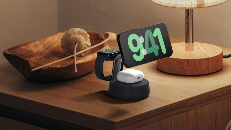 An iPhone, Apple Watch and AirPods all charging on a wireless charging stand.