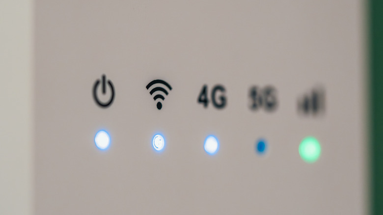 Close-up of a wireless router showing illuminated power, Wi-Fi, 4G and signal-strength indicators.
