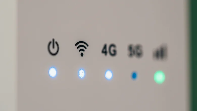 Close-up of a wireless router showing illuminated power, Wi-Fi, 4G and signal-strength indicators.