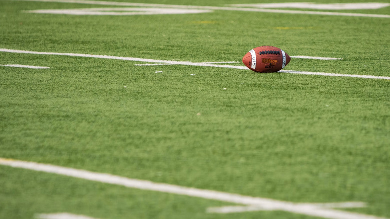 A lonely football on a field.