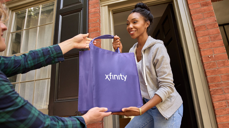 A woman accepts a package likely containing a modem.