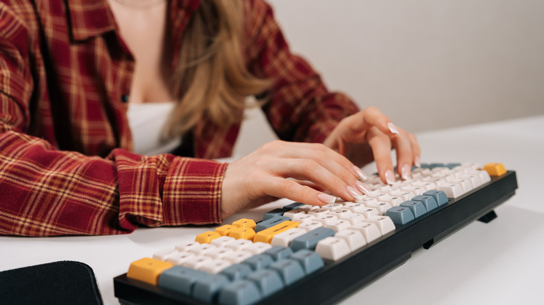 Woman typing on custom mechanical keyboard.