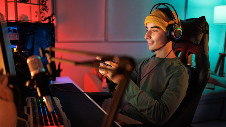 Young man wearing a wired headset playing a game