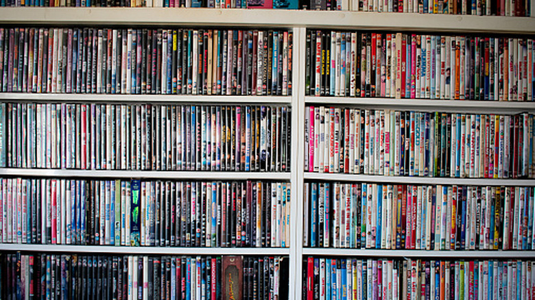 A shelf displays a colorful stack of Blu-rays and DVDs.