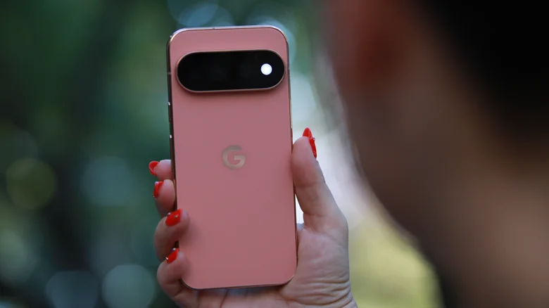 A pink Google Pixel 11 Pro being held, showing the back side with the camera.