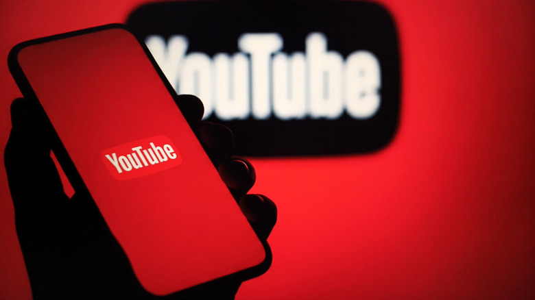 YouTube logo is shown on a telephone with a red background against another black youtube logo, also against a red background