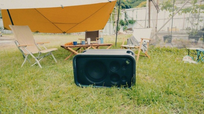 A speaker outside near a table and chair.