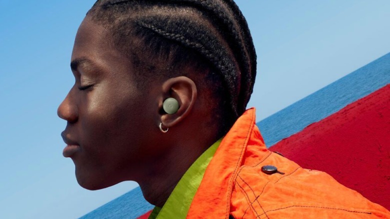 A man wears green earbuds.