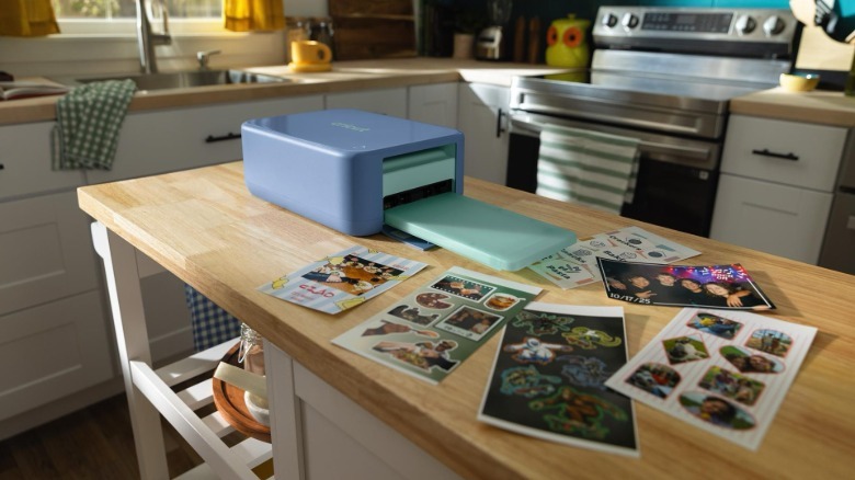 The Cricut StickerPix Print+Cut surrounded by printed stickers.