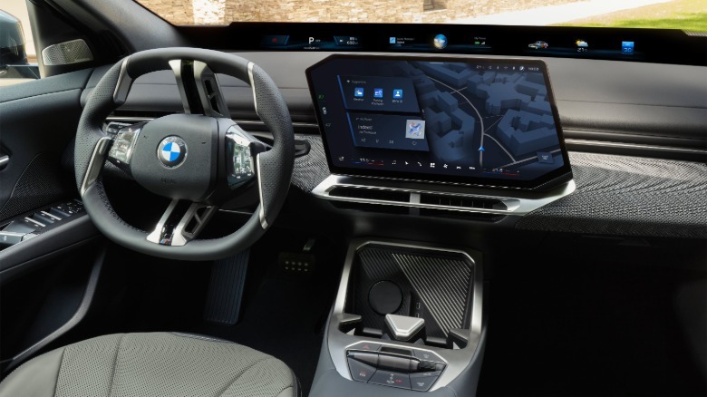 BMW iX4 50 interior is shown with a 17.9-inch touchscreen and vertical spoke steering wheel