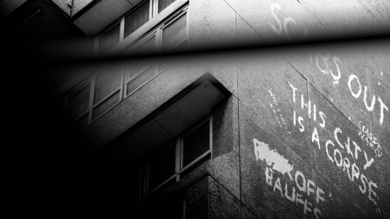 A screenshot from Signet City. A agelong of graffiti connected nan broadside of a building declares