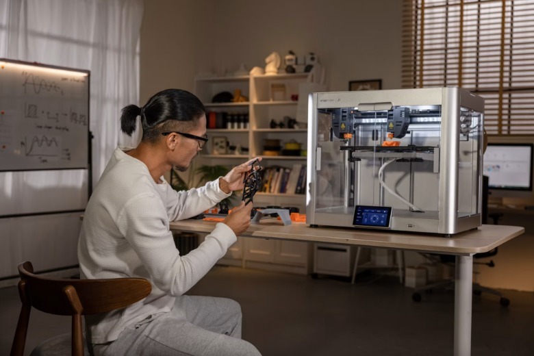 A man prototypes using a 3D printer.