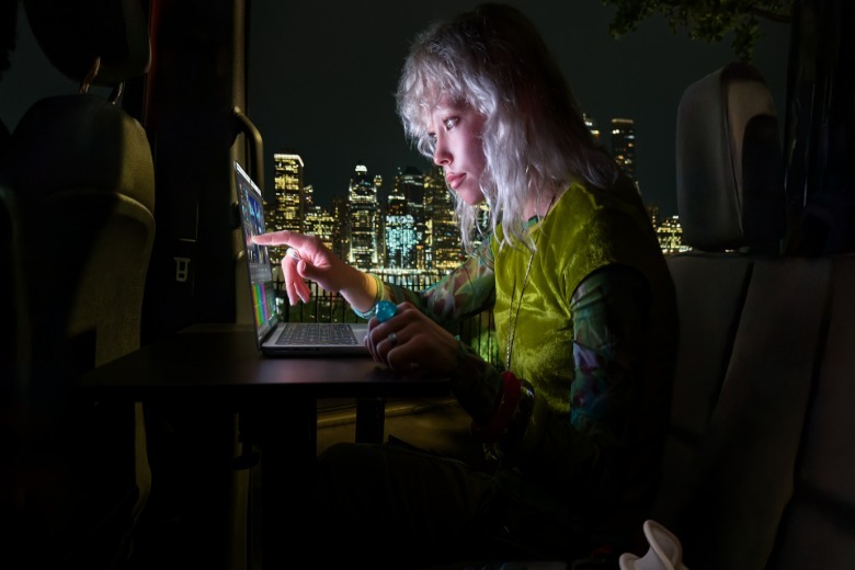 Someone using a MacBook Pro OLED touchscreen.