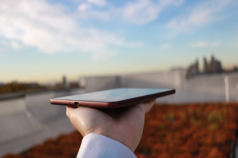 The fig Kindle Colorsoft Signature Edition held out on a palm
