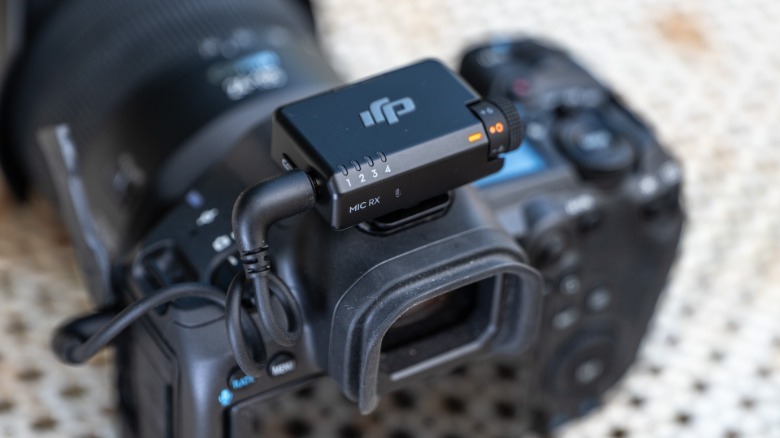 DJI's Mic Mini 2S transmitter is shown mounted on a mirrorless camera